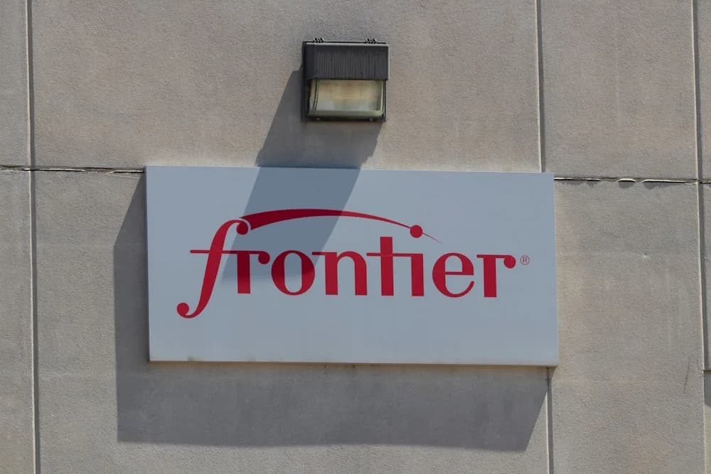 The red Frontier logo on a white sign mounted to a grey concrete wall